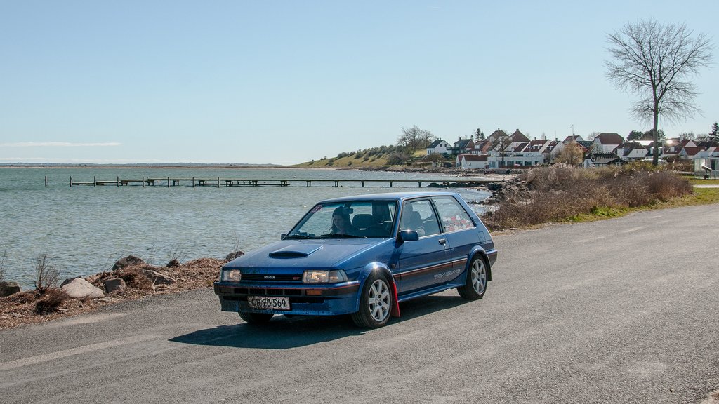 Løbsleder for Sports Motor Klubben Gladsaxes løb den 10. maj, Kim Bach Sørensen, ses her i den fine Toyota Corolla GT fra 1986. Sammen med datteren Freja Damgaard Sørensen passerer de her Dyreborg på Fyn under årets 1. afdeling.
(Foto: rallypics.dk / Viggo Johansen)